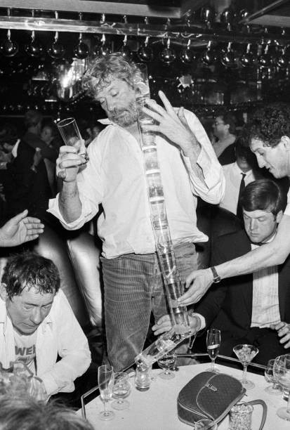 Oliver Reed balancing glasses top of each other at his girlfriends- Old Photo 10