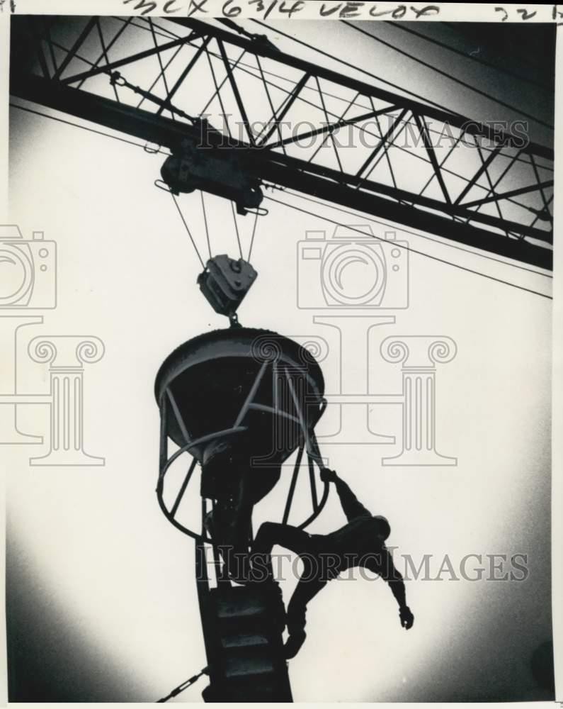 1975 Press Photo Construction worker hanging on a crane above Poydras Street