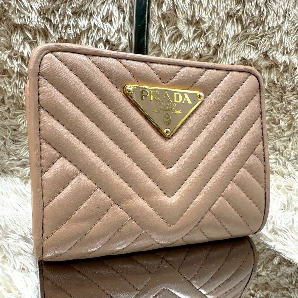 Prada beige bifold wallet with triangle logo for women in good condition