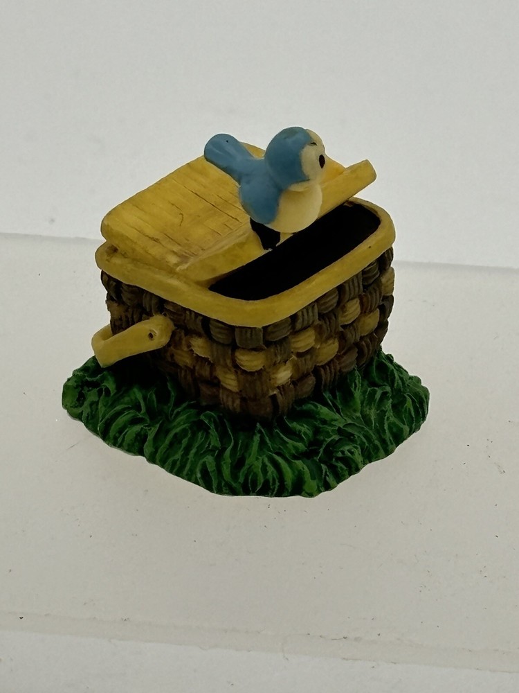 Blue bird perched on woven picnic basket with rustic charm