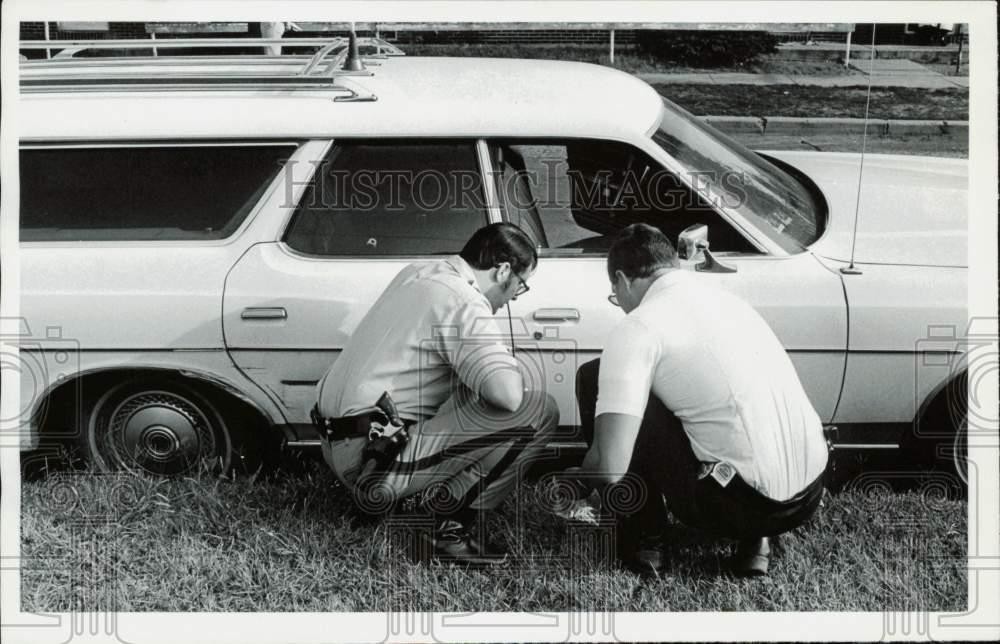 1979 Press Photo Police officers inspect the exterior of a car - lra32987