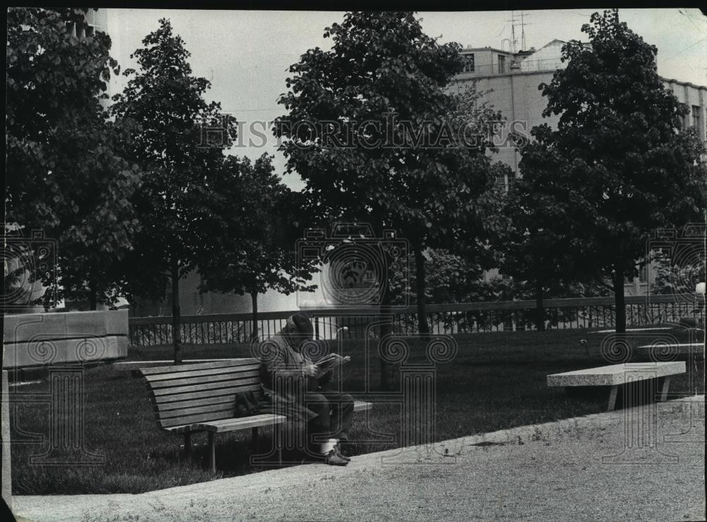 1981 Press Photo An elderly man reading at a bench at the Civic Center Plaza