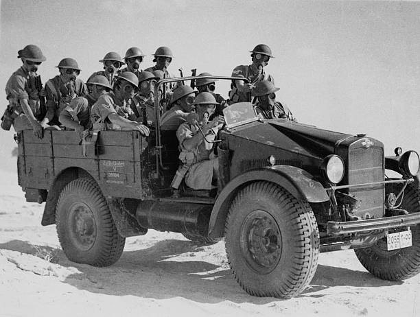 Truck of British soldiers wearing gas masks depart for military tr- Old Photo