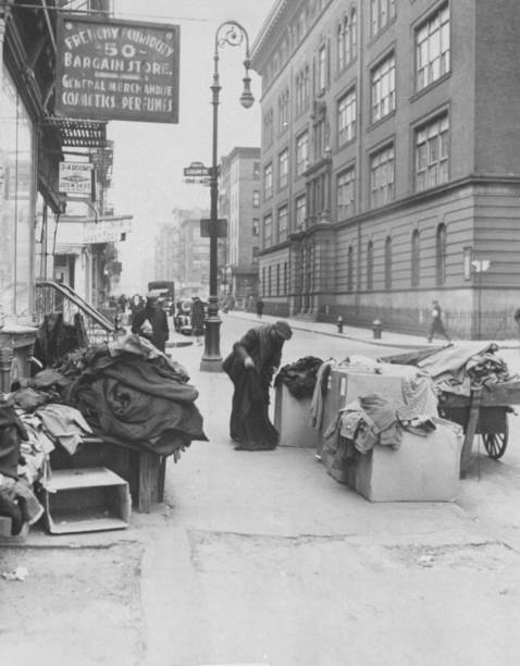 Man looks in boxes of clothes outside a shop on the lower East Sid .. Old Photo