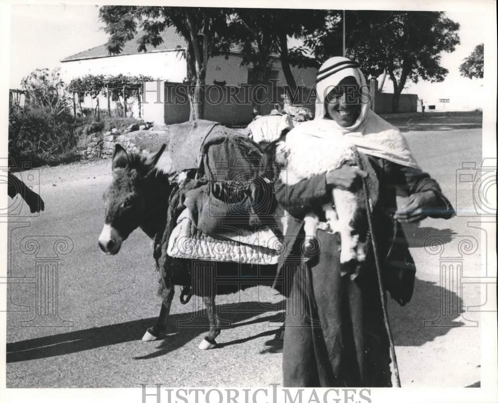 1962 Press Photo Bedouin With Donkey Carries Lamb Near City Of Jericho, Israel