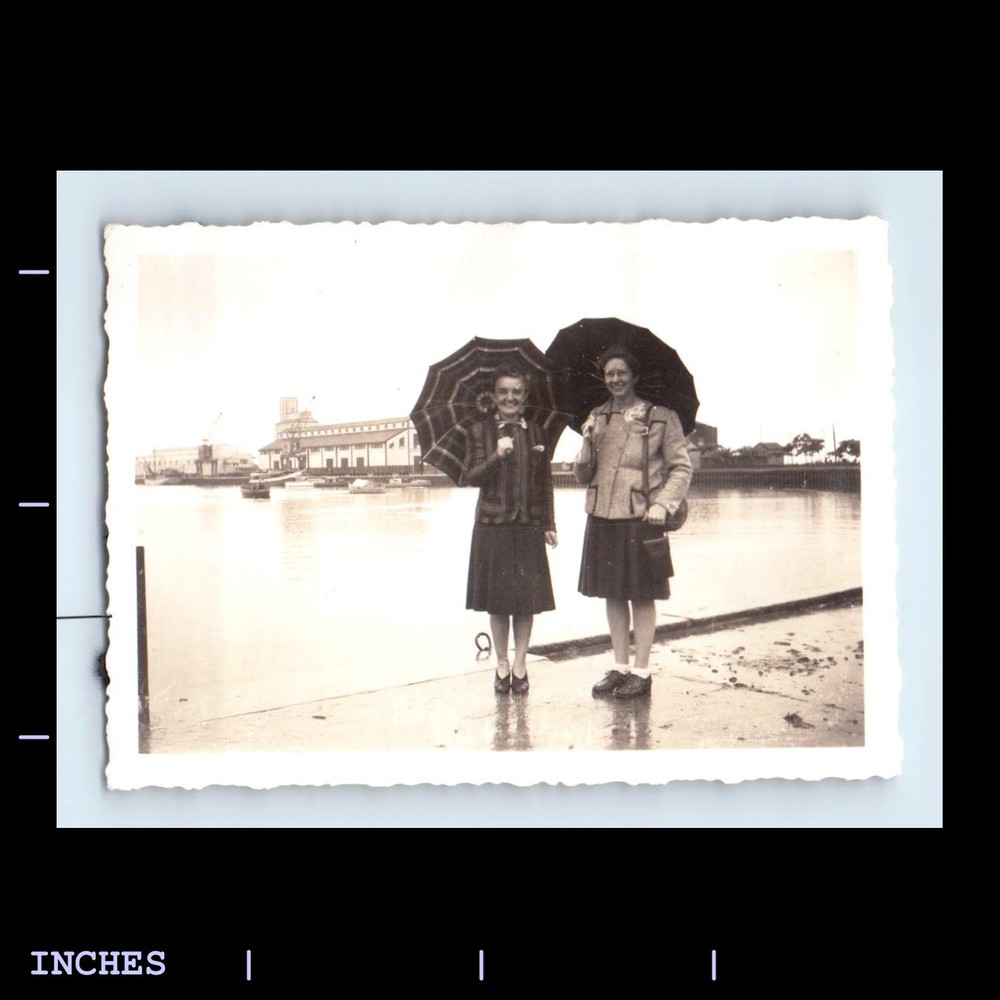 Vintage woman holding umbrella standing outside retro photo