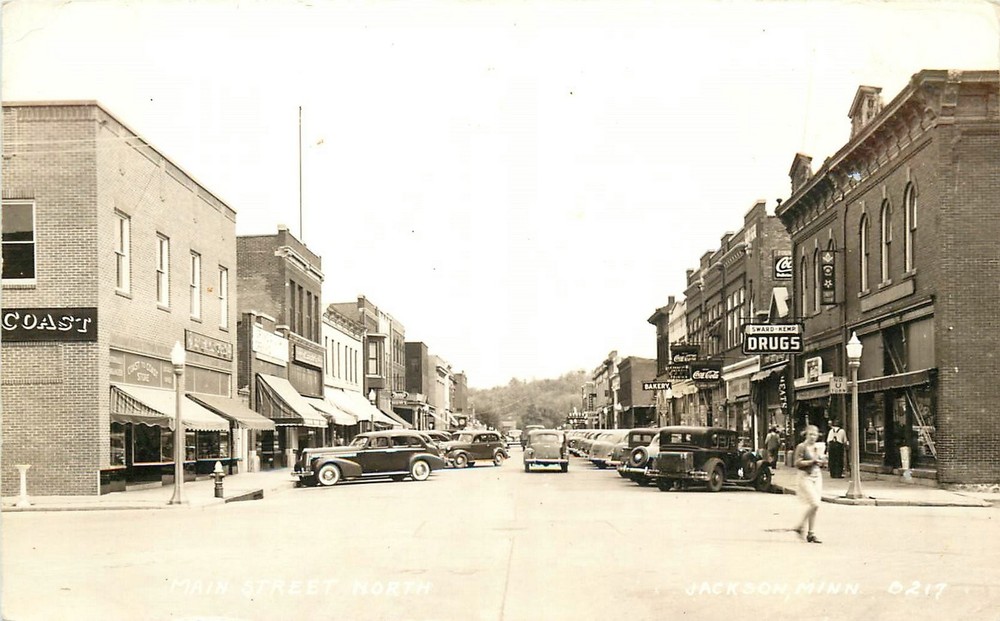 1940s Jackson Minnesota Main Street autos Coca Cola RPPC Postcard 25-7912