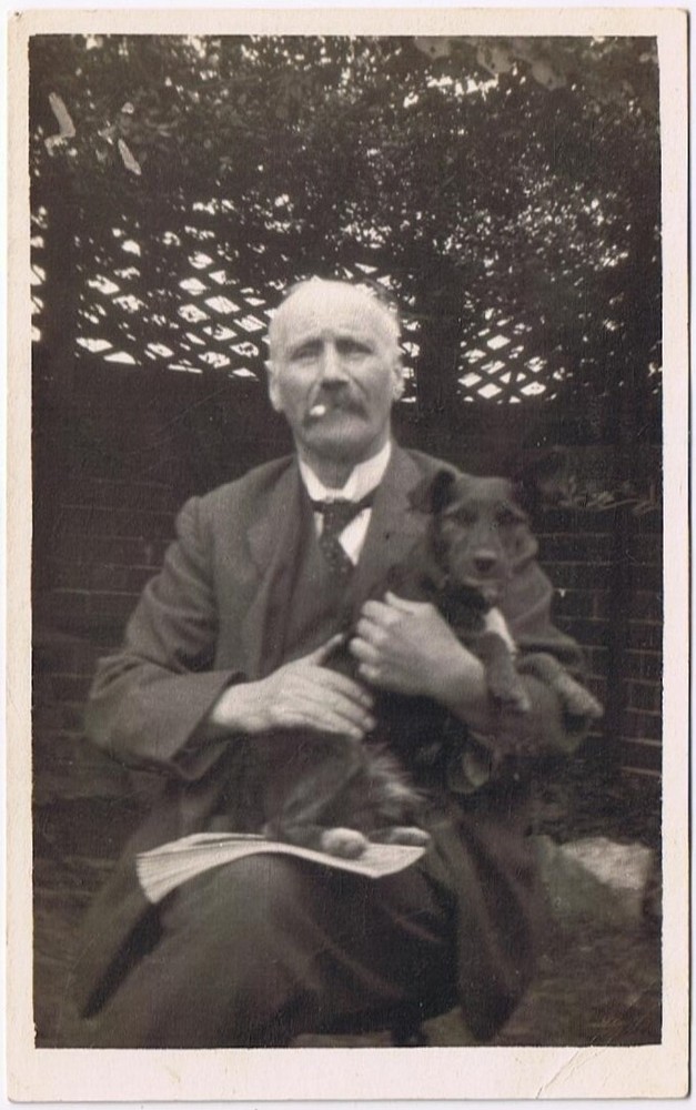 Gentleman with Moustache Smoking and Dog on Lap Holding Newspaper