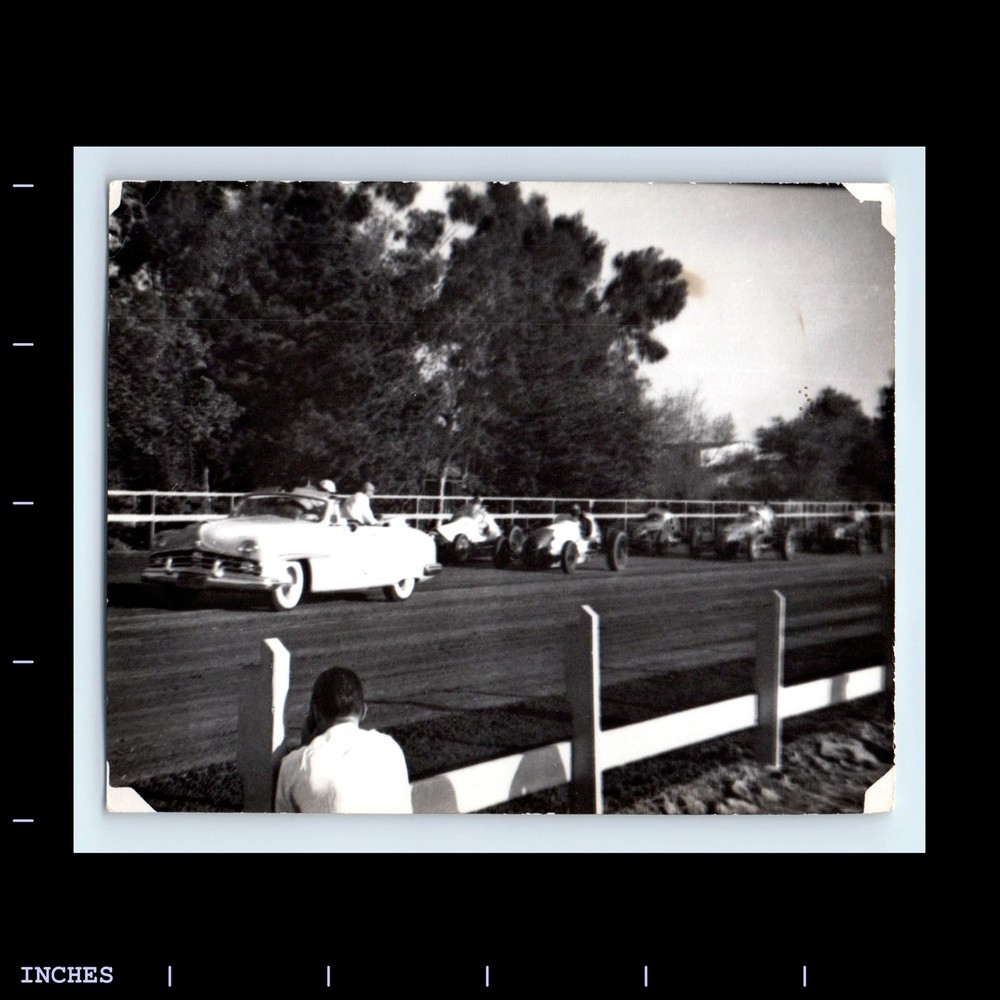 Vintage photo of man with camera at race track classic cars speedway