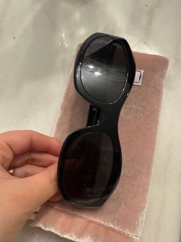 Stylish Miu Miu  sunglasses. Sleek black frame. Perfect for any occasion.