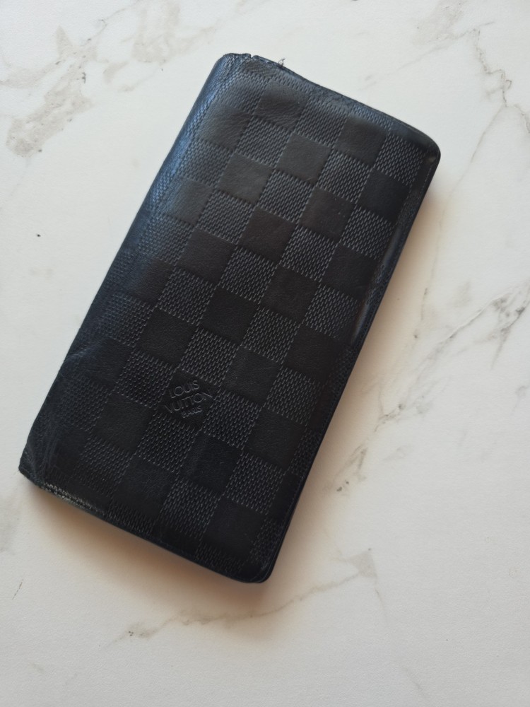 Authentic Louis Vuitton Damier Infini long wallet in black leather.